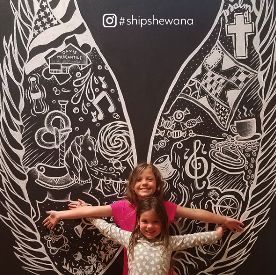 Children posing with wall art