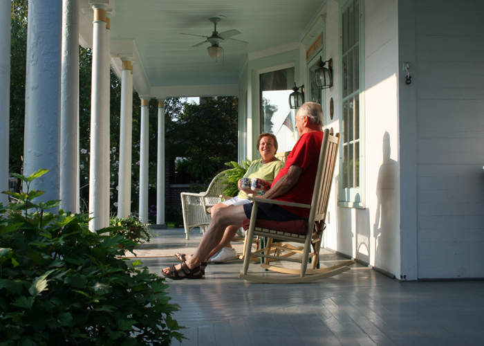 Two people sitting on porch in rocking chairs