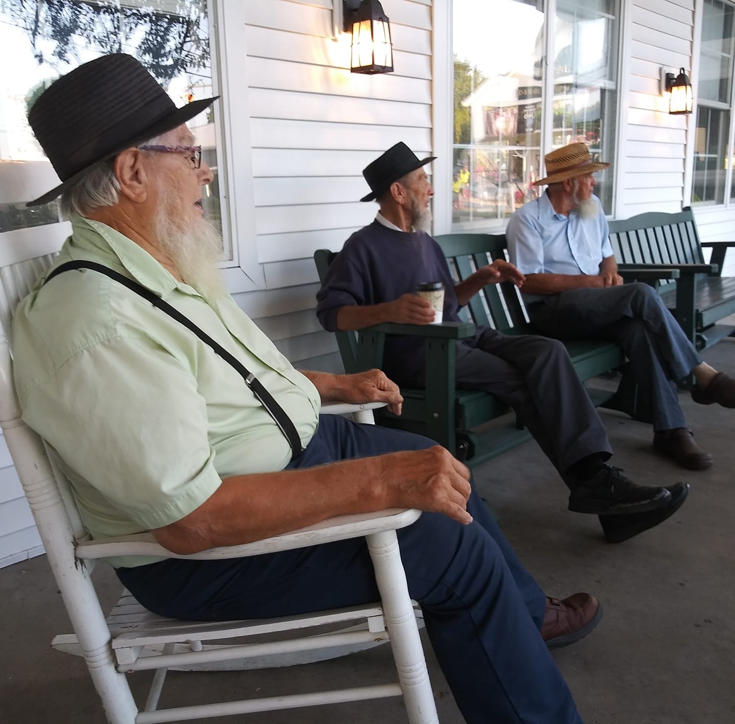 Amish men on a porch.