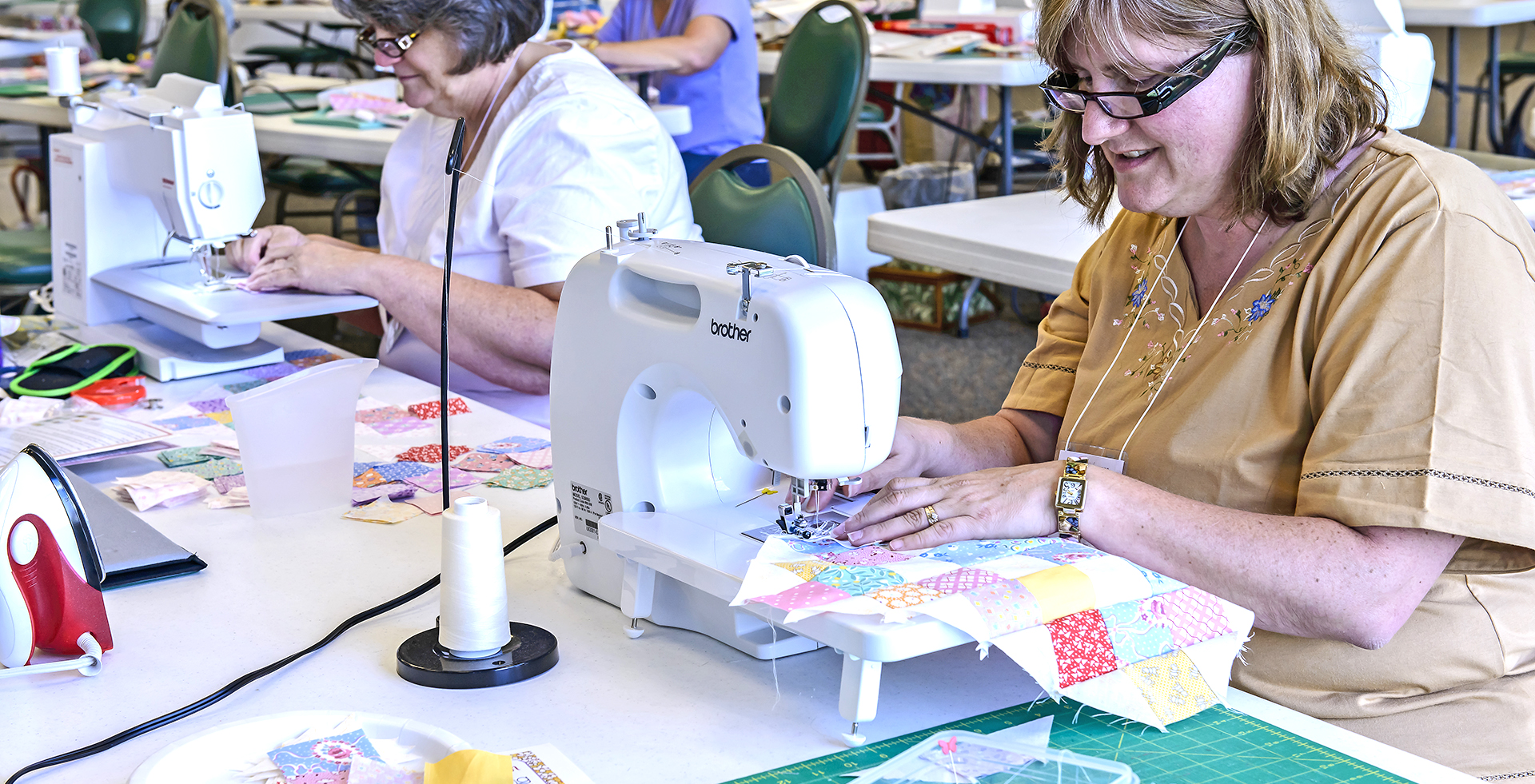 People sewing a quilt