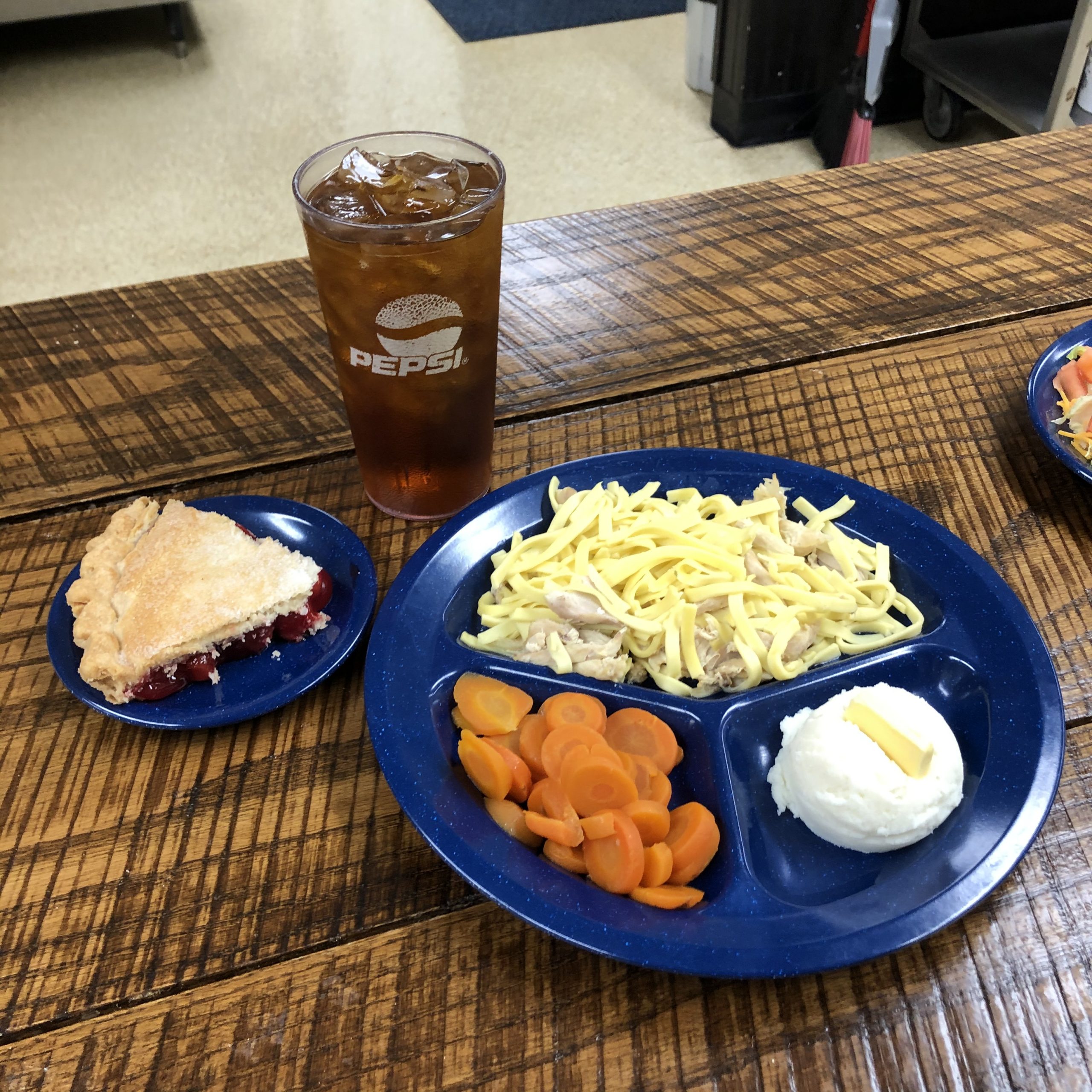 Chicken and noodles with mashed potatoes, carrots, cherry pie and a fountain drink