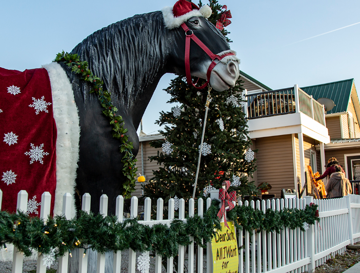 horse status in Christmas village wearing Santa hat