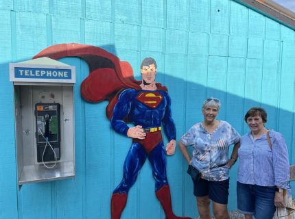 Two ladies posing with Superman